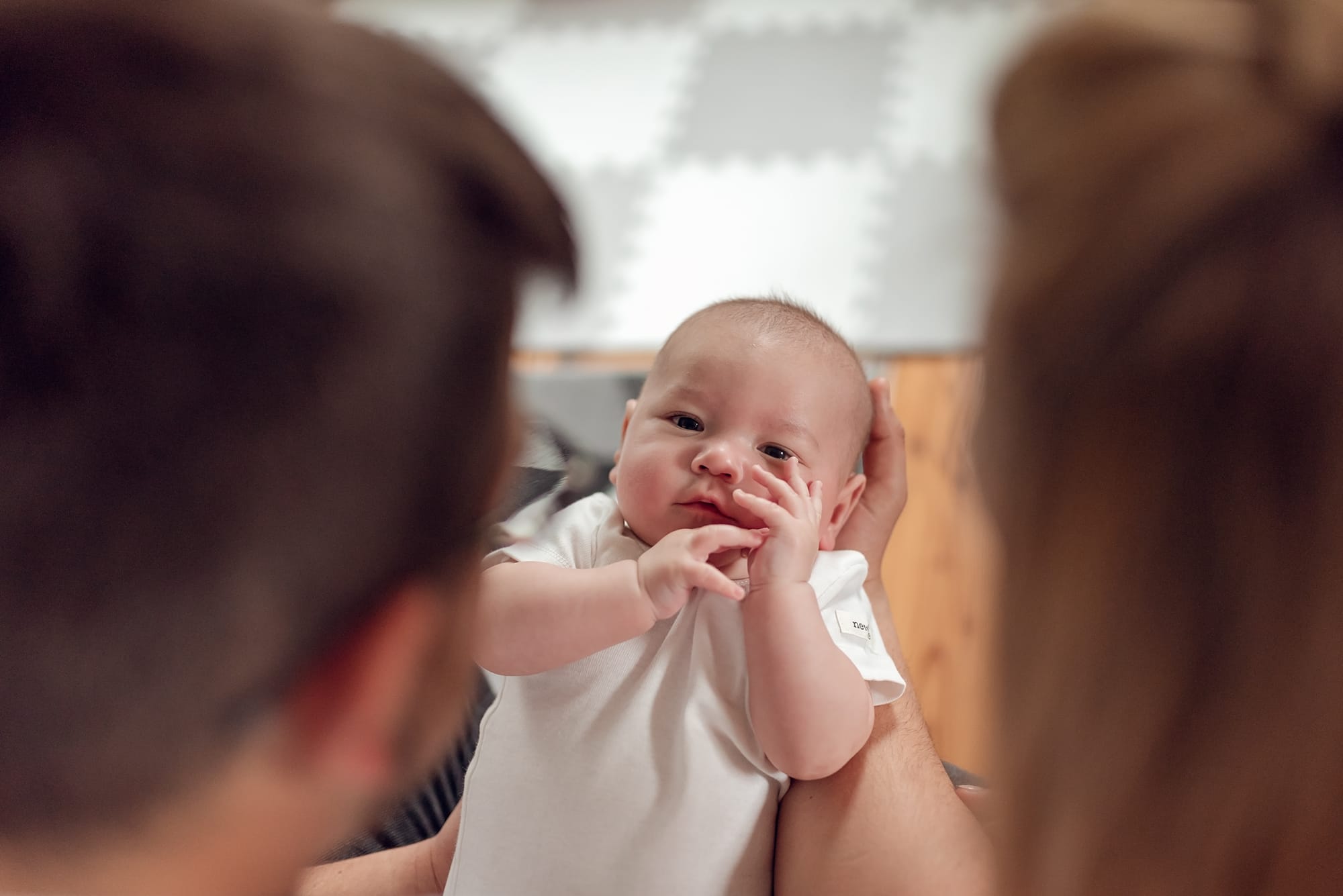 Niemowlę między rodzicami naturalna sesja w domu