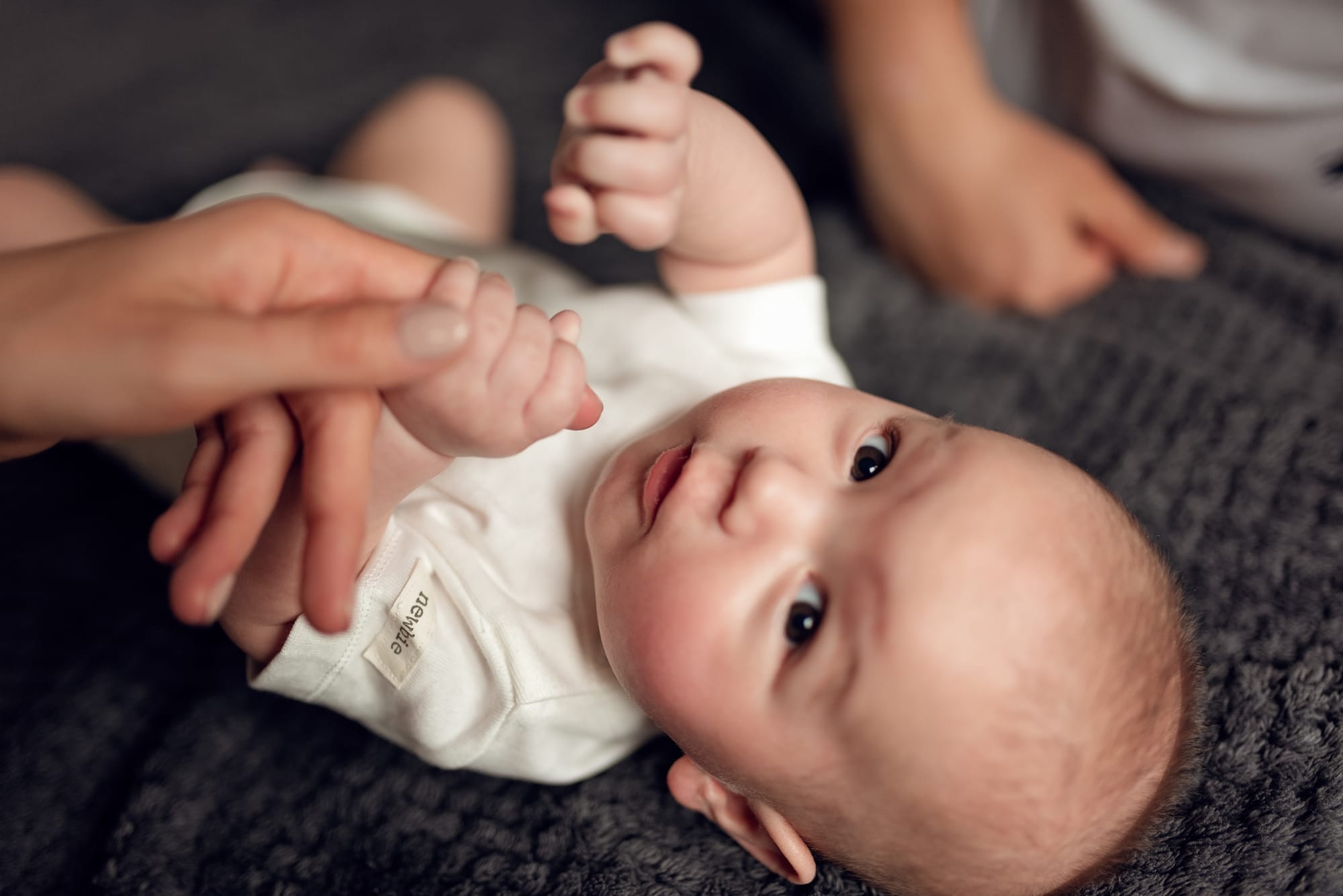 Niemowlę chwyta palec mamy sesja w domu