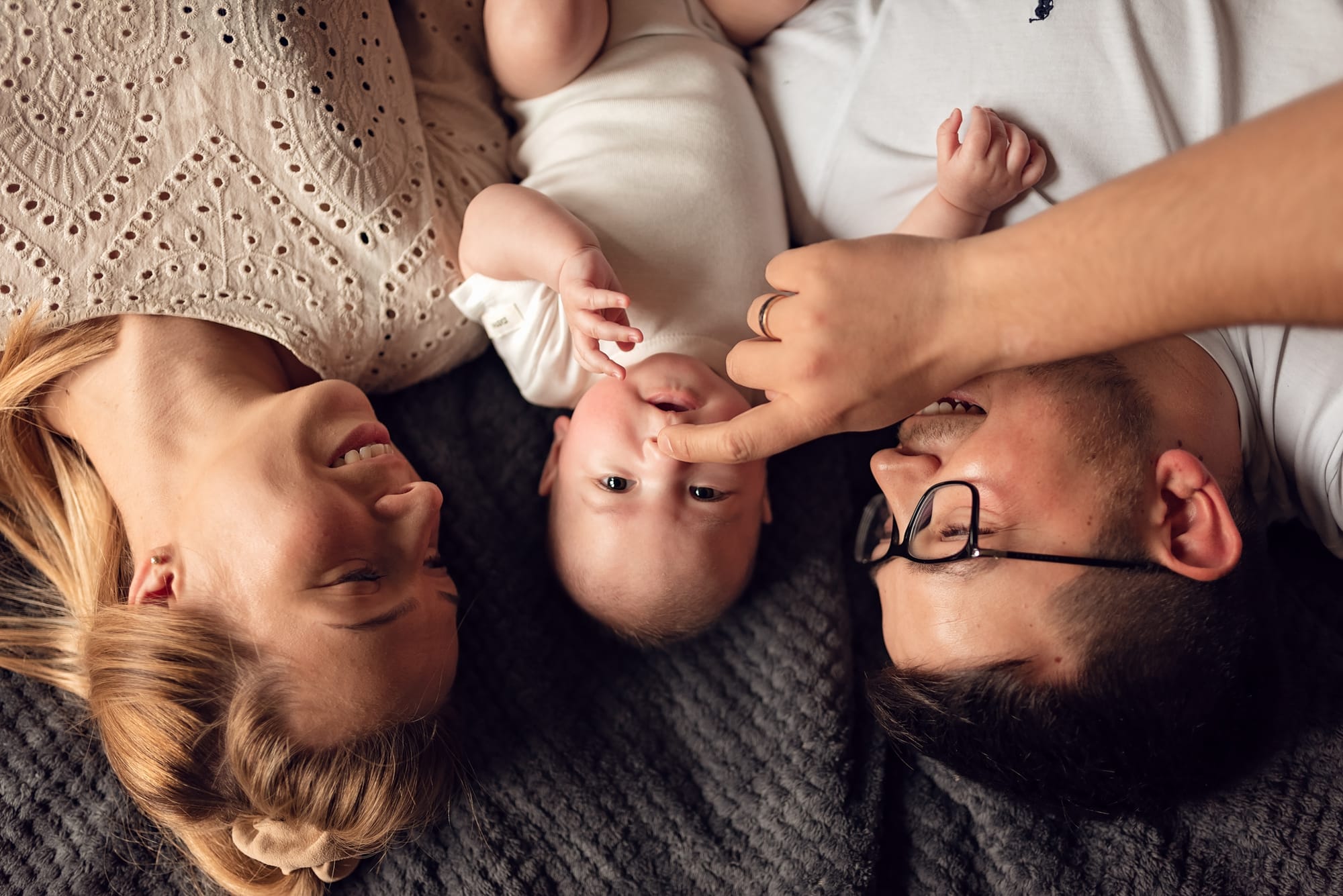 Tata dotyka noska niemowlęcia sesja niemowlęca w domu