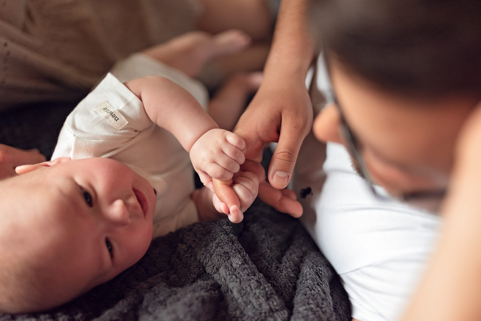 Niemowlę ściska palec taty naturalna sesja w domu