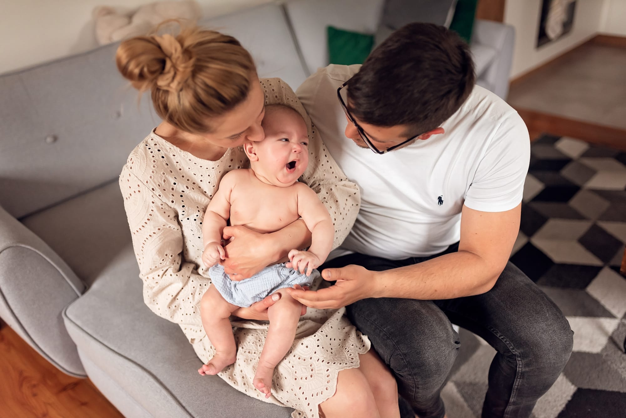 Niemowlę ziewa na mamie tata obserwuje sesja w domu