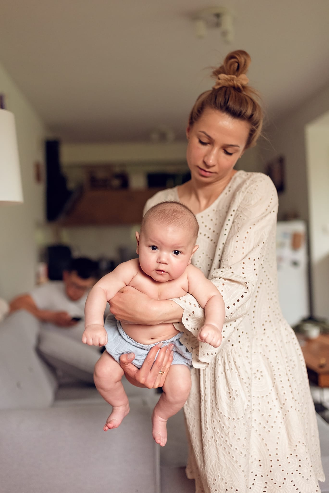 Mama buja niemowlę tata z telefonem sesja w domu
