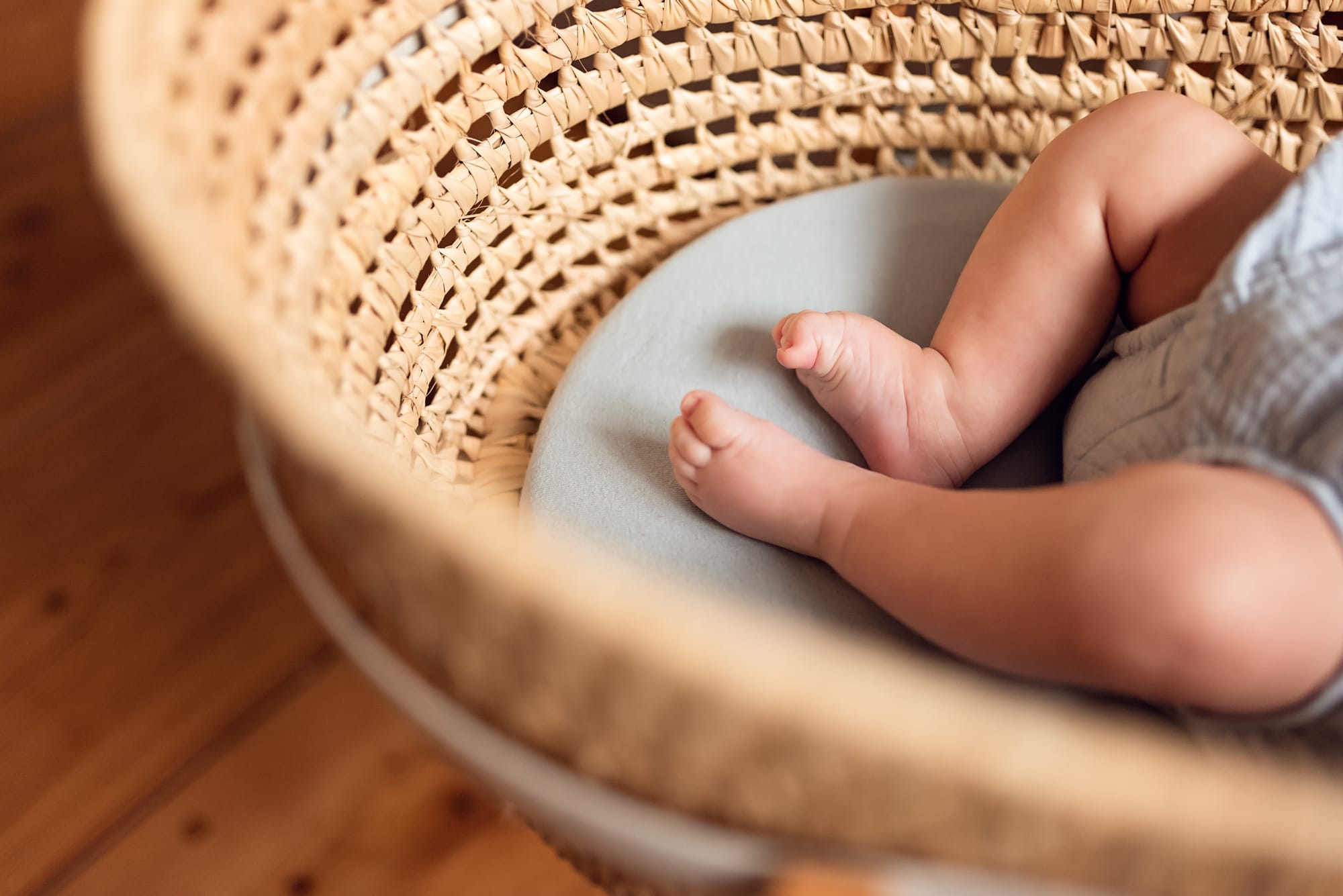 Stópki niemowlęcia w koszu mojżesza sesja w domu