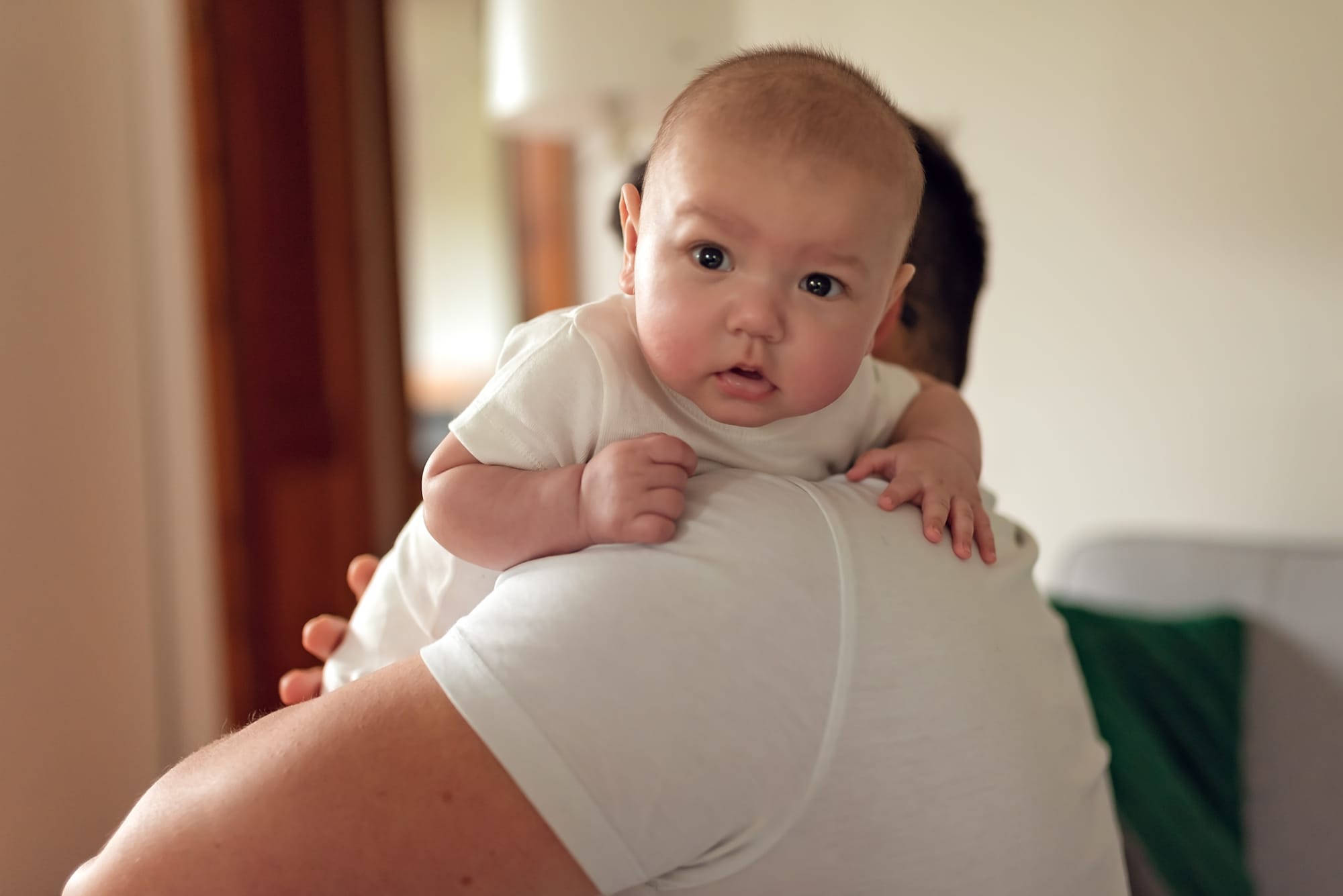 Tata odbija niemowlę po karmieniu sesja niemowlęca w domu