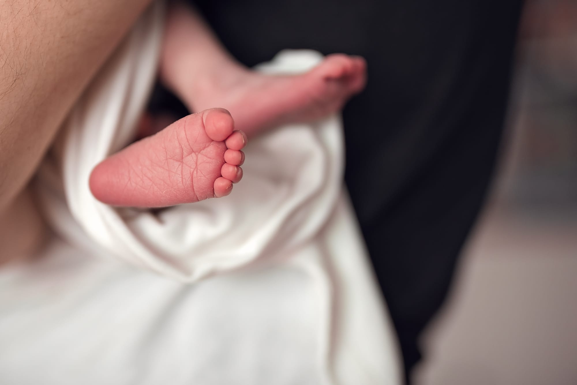 Stópka noworodka na jasnym kocyku sesja w domu