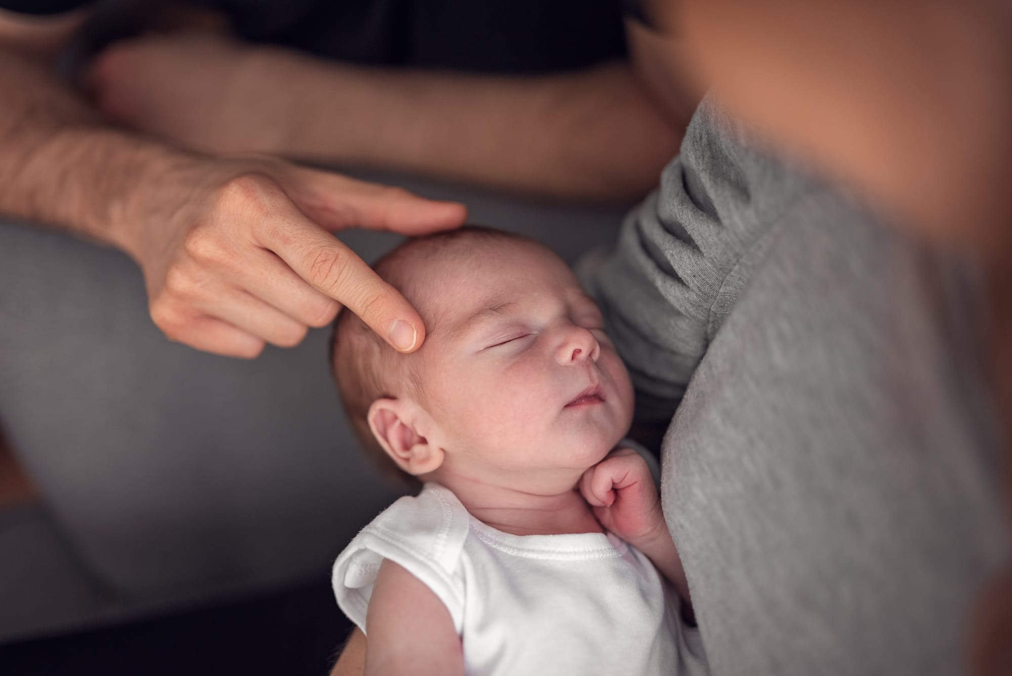 Rodzice z noworodkiem na fotelu przy oknie sesja w domu