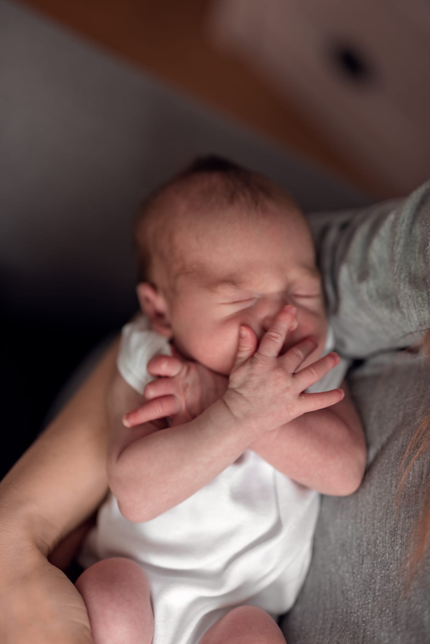 Noworodek na kolanach mamy sesja noworodkowa w domu