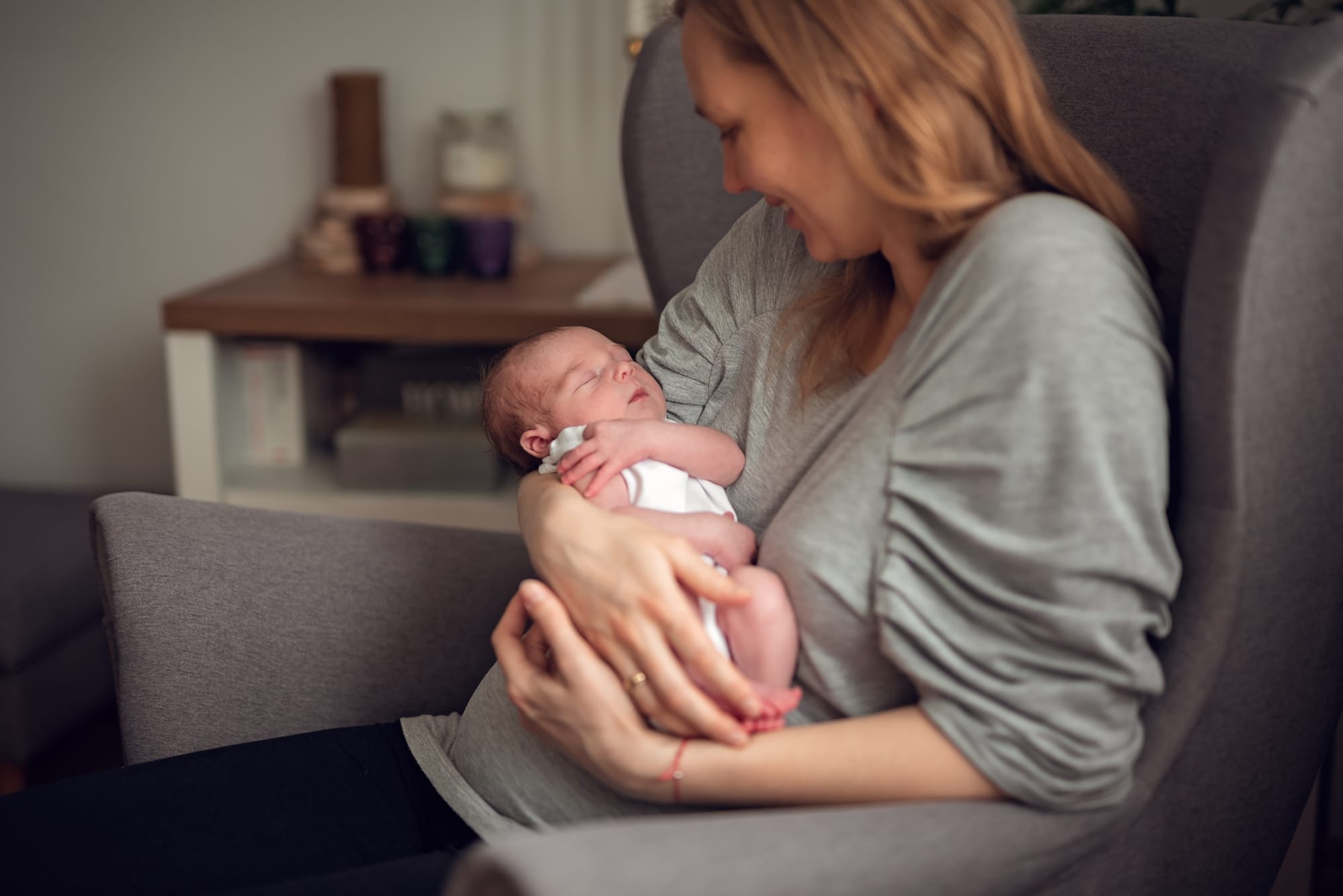 Mama patrzy na noworodka sesja noworodkowa w domu