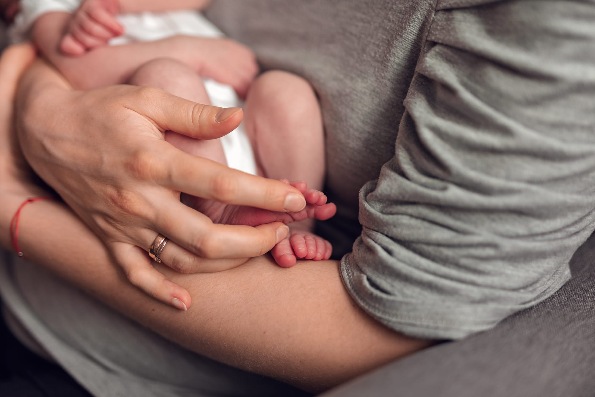 Noworodek w ramionach mamy sesja noworodkowa w domu