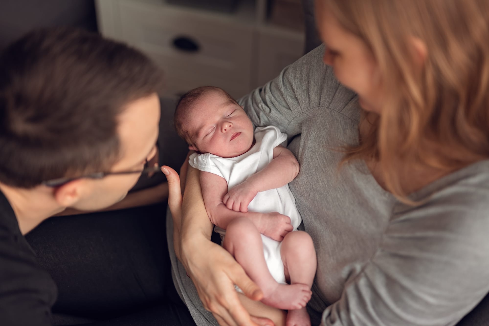 Rodzice z noworodkiem sesja w jasnym mieszkaniu