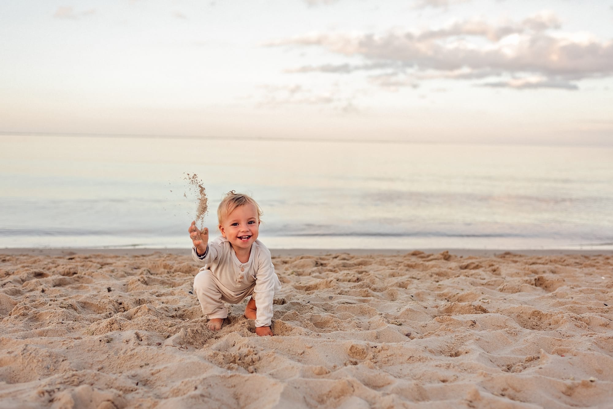 Chłopiec sypie piaskiem sesja rodzinna na plaży Gdynia