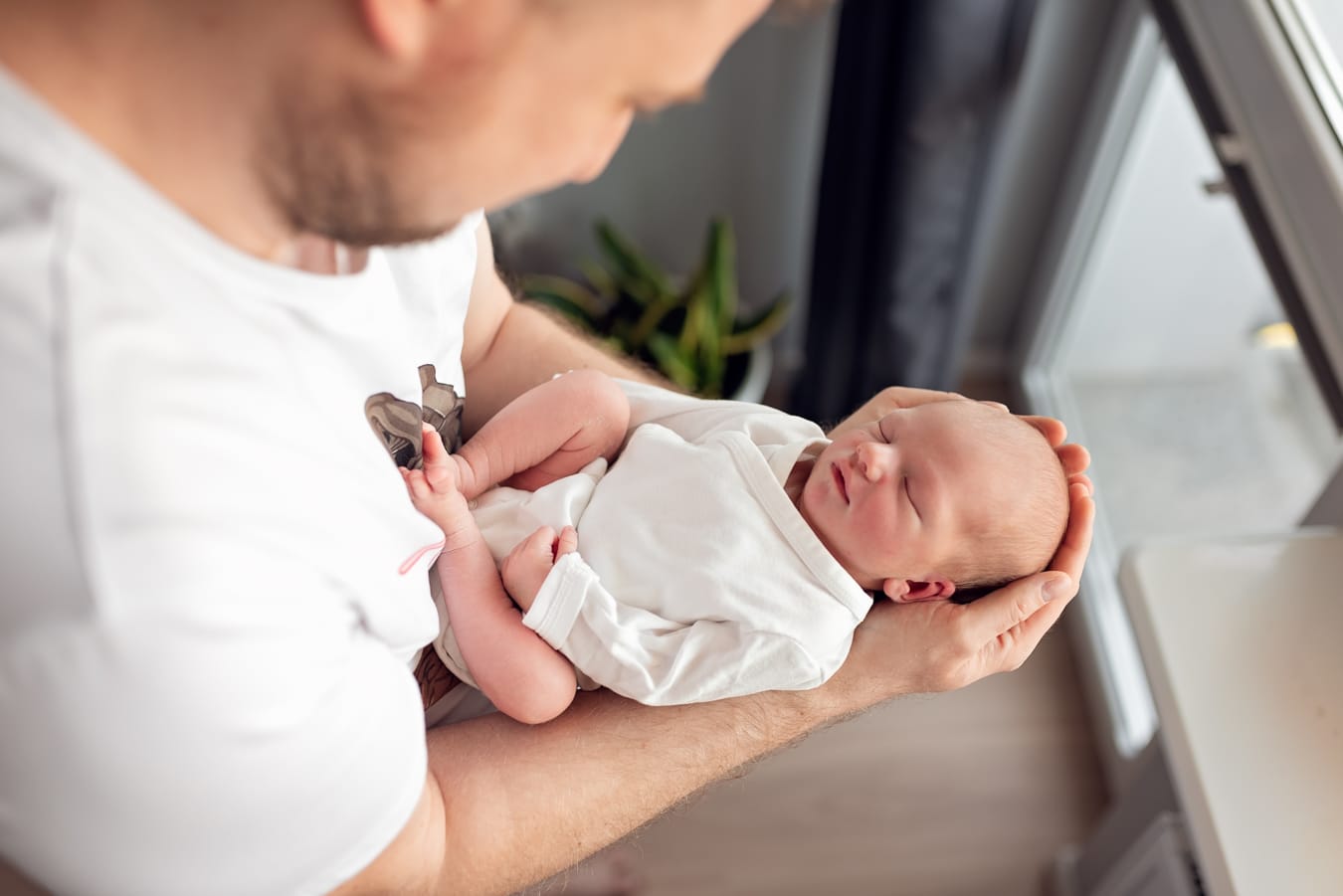 Tata z noworodkiem na rękach sesja w domu Sopot