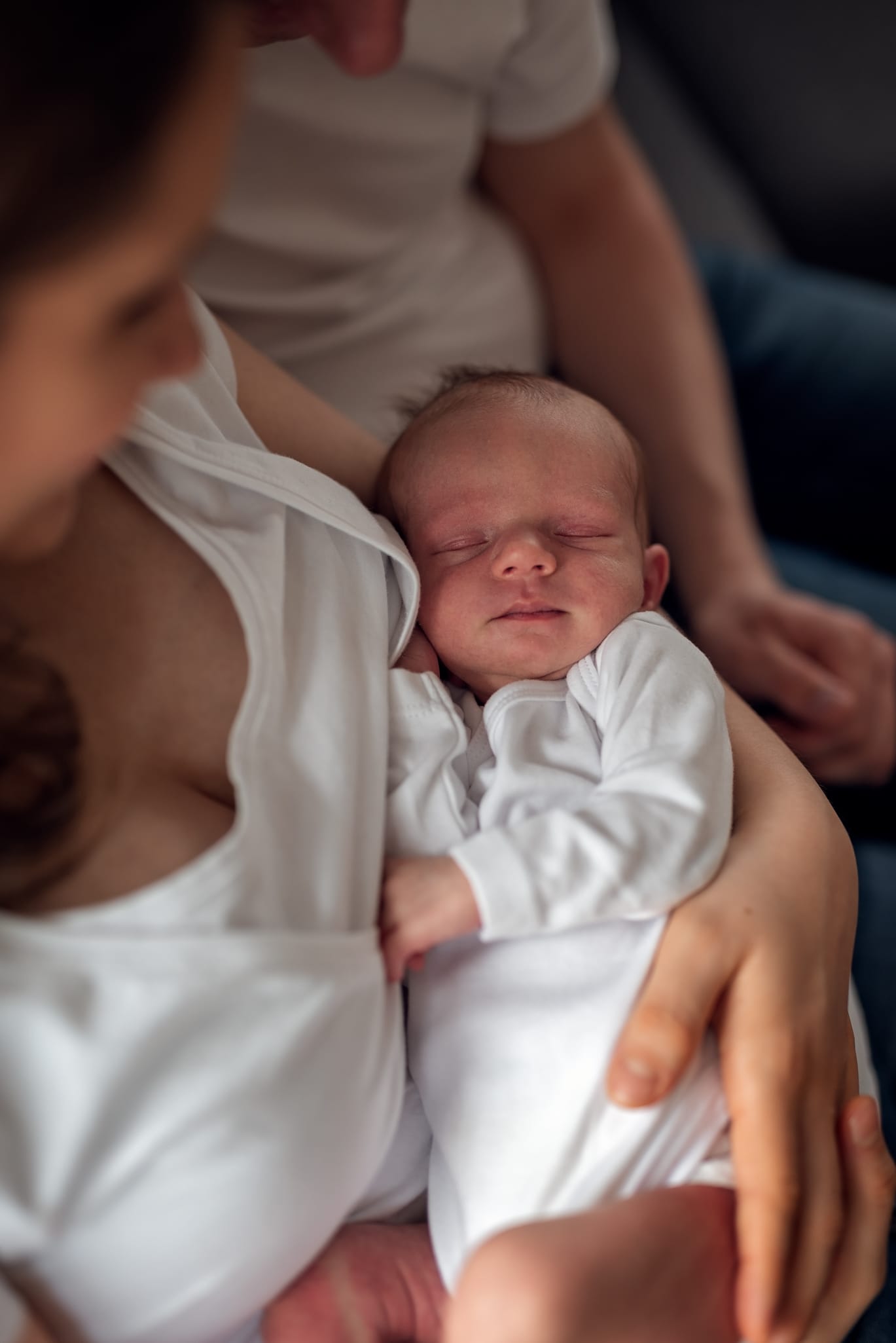 Noworodek śpi w ramionach sesja noworodkowa w domu