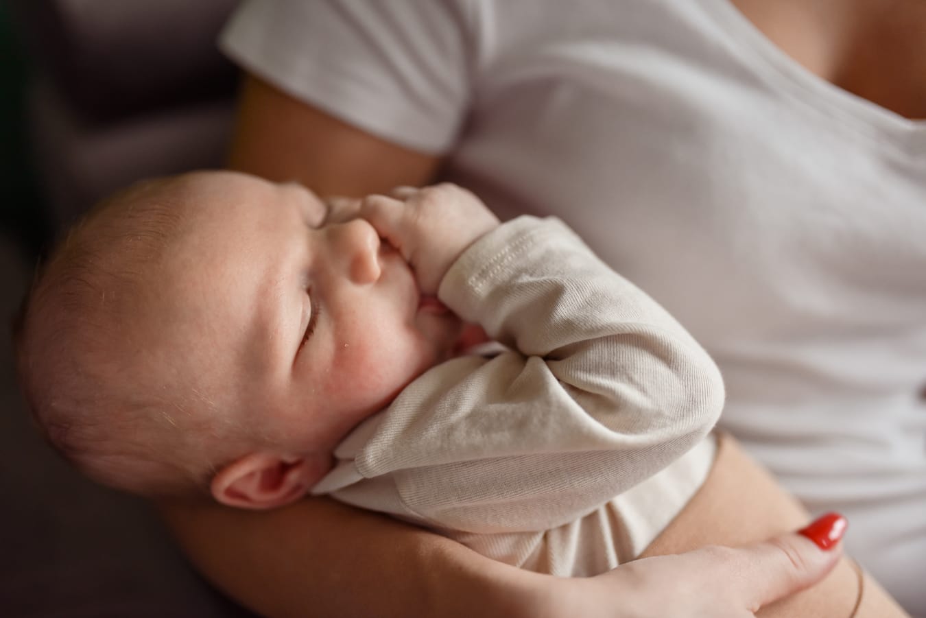 Niemowlę ssie kciuk na rękach mamy sesja Gdynia