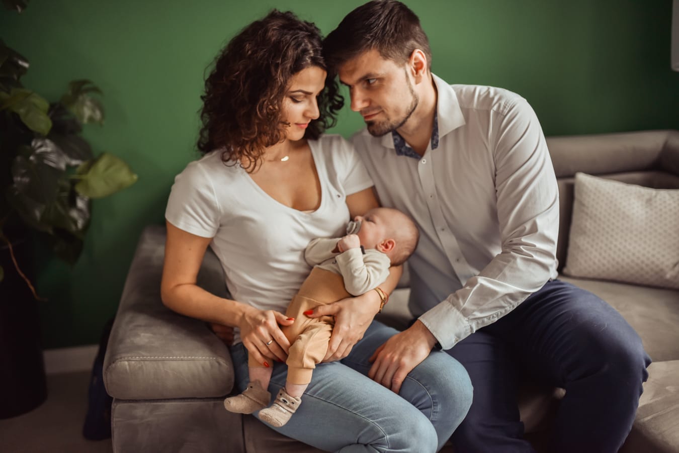 Rodzice z niemowlęciem na kanapie sesja w domu Gdynia