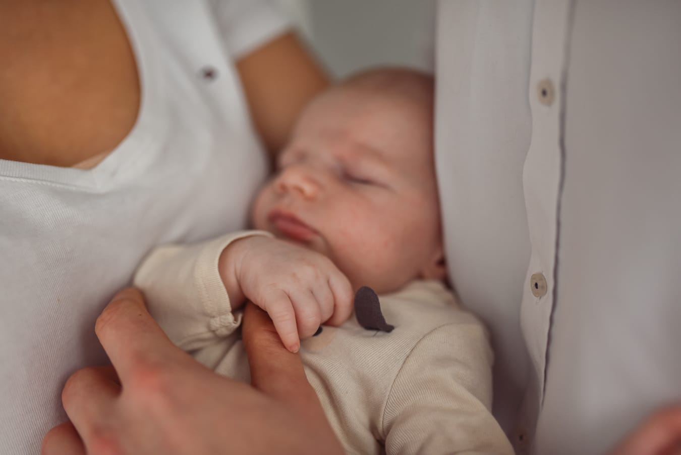 Niemowlę trzyma palec taty sesja z niemowlęciem naturalne światło sesja w domu