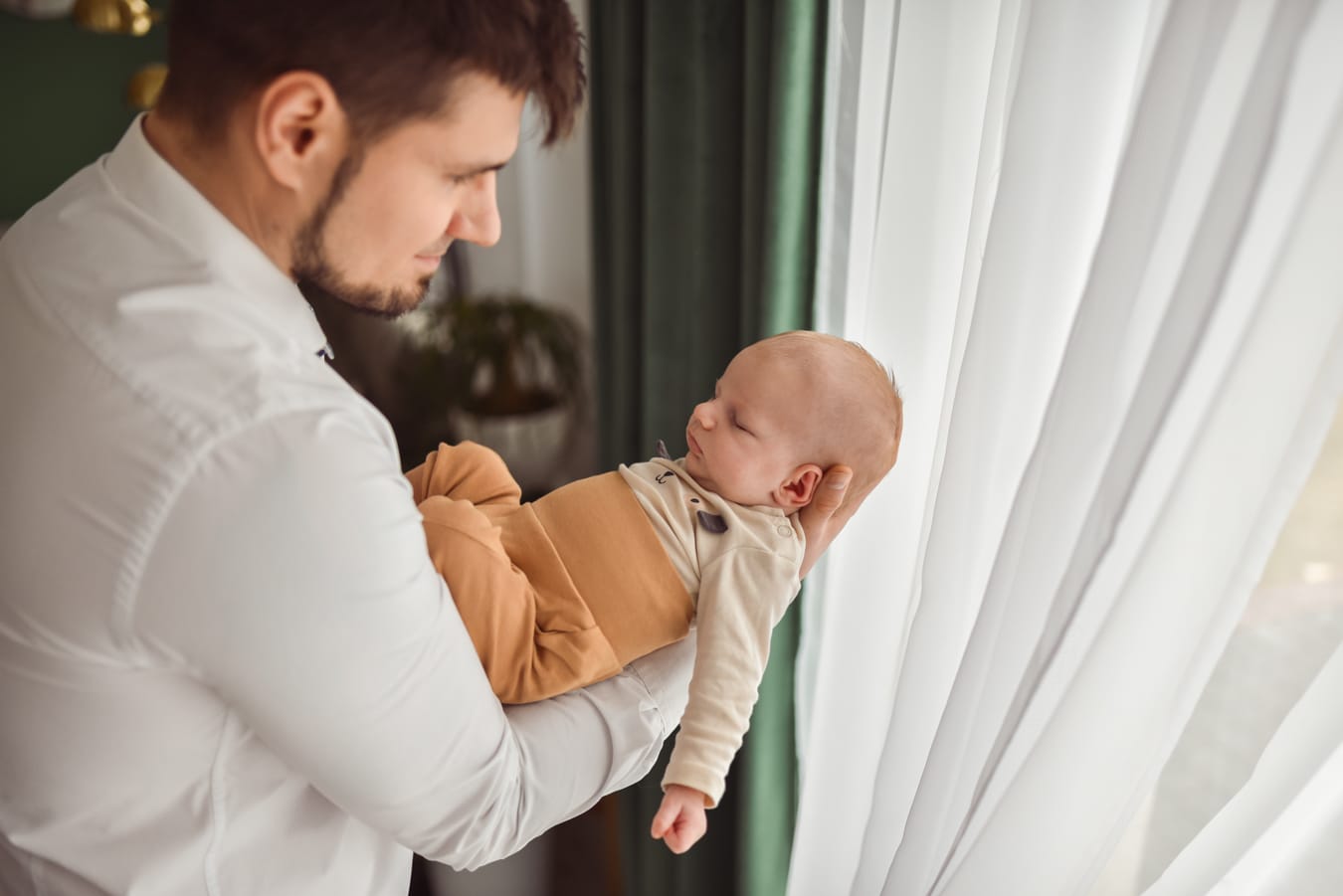 Niemowlę na rękach taty sesja w domu Gdynia
