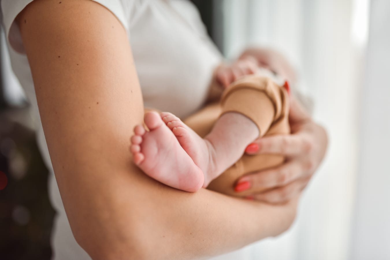 Stópki niemowlęcia w ramionach mamy sesja Gdynia