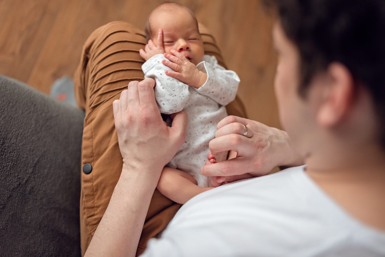 Śpiący noworodek na kolanach taty optymalny czas na sesję