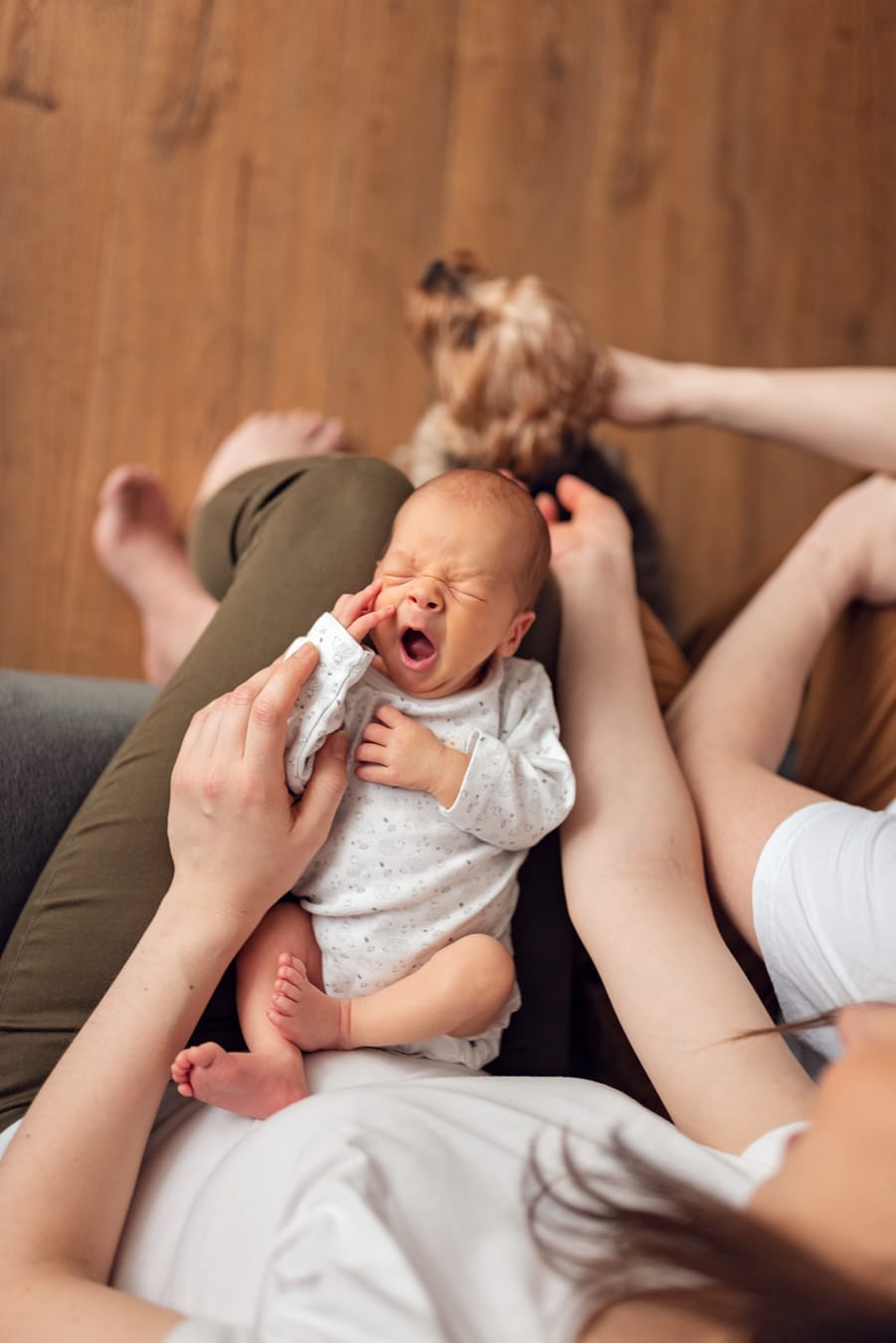 Ziewający noworodek na kolanach mamy sesja Gdańsk