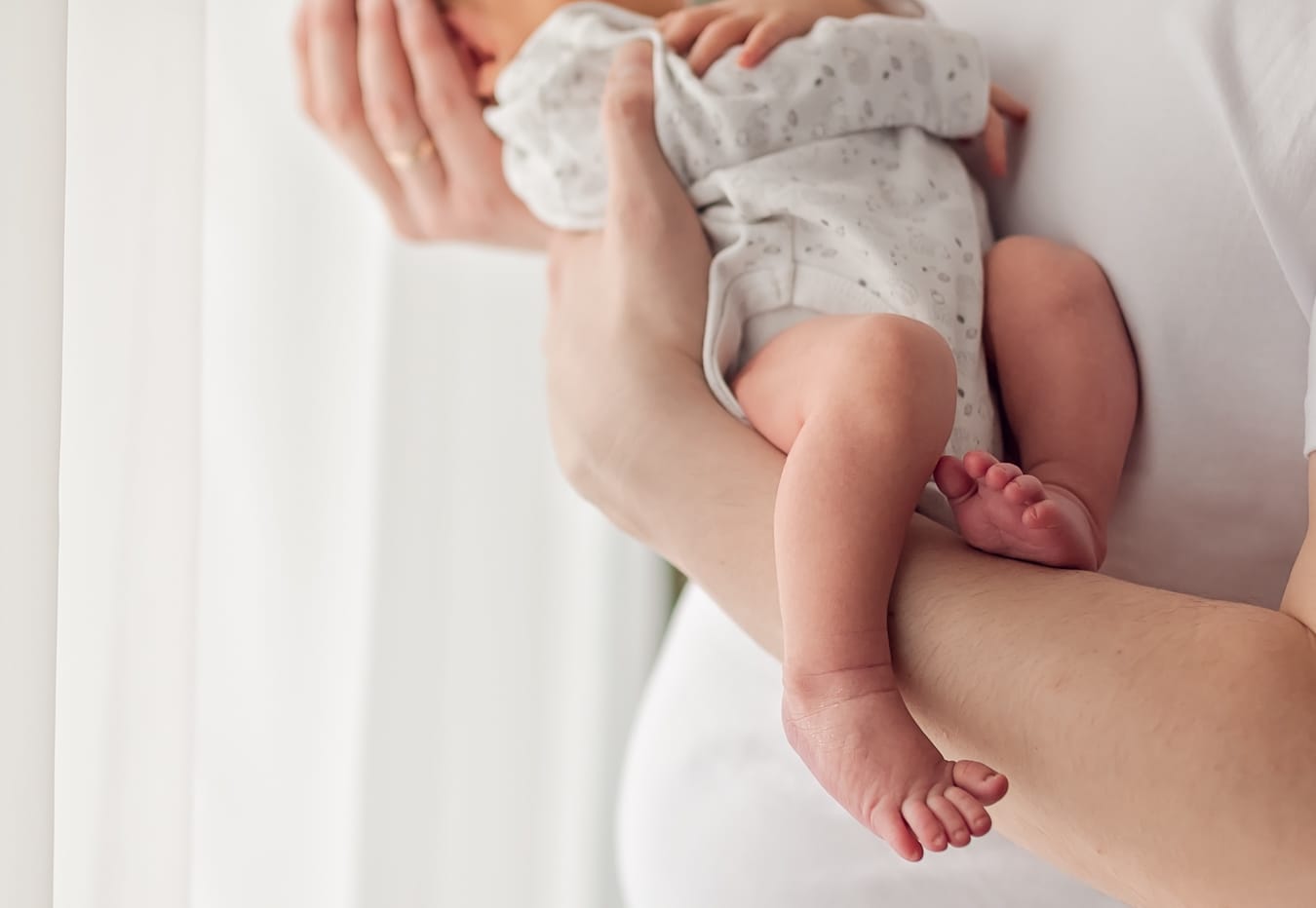 Nóżki noworodka na rękach taty detal sesja Gdańsk