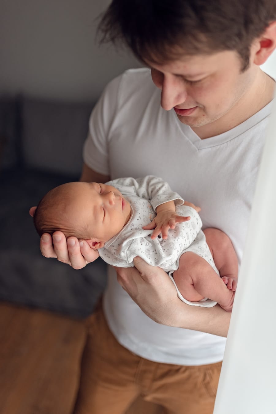 Tata patrzy na noworodka sesja noworodkowa Gdańsk