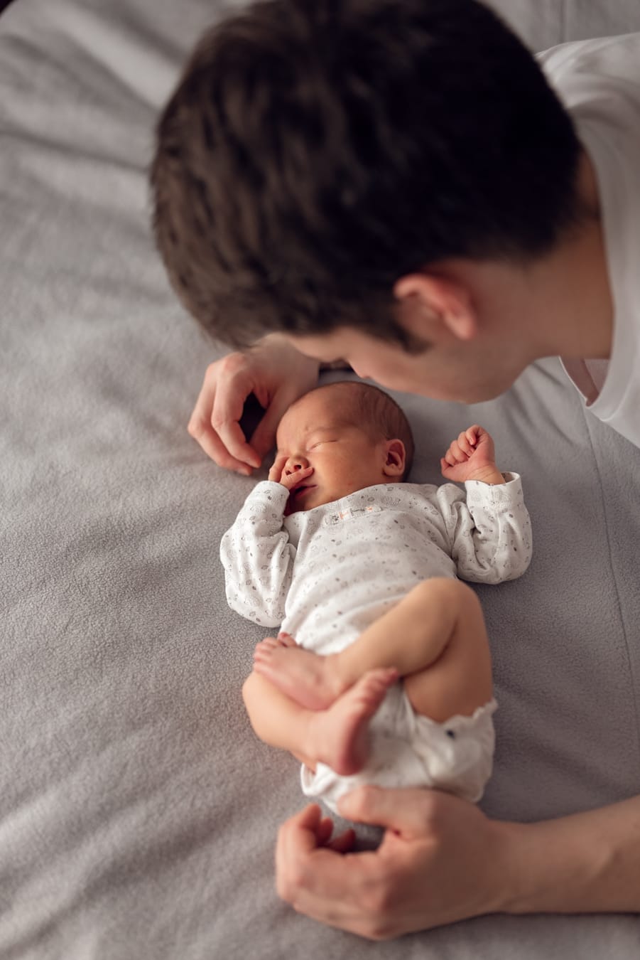 Tata nad śpiącym noworodkiem sesja w domu Gdańsk