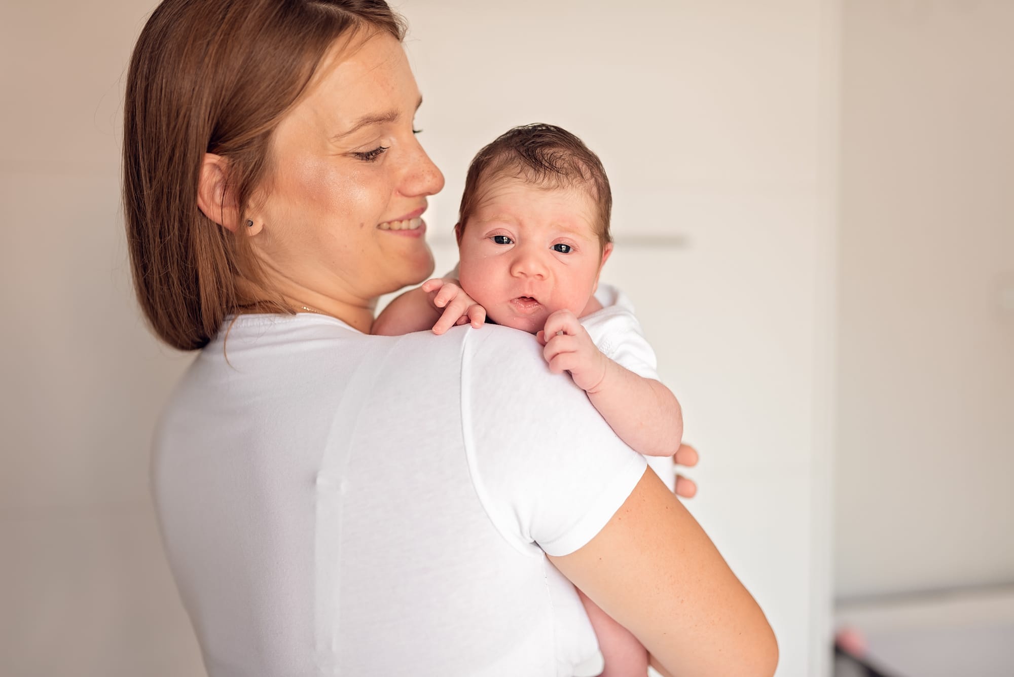 Noworodek zza ramienia mamy sesja noworodkowa Trójmiasto