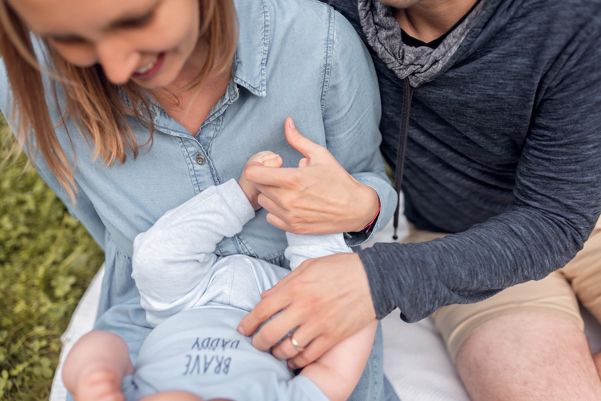 Rodzice z niemowlakiem sesja w plenerze na łące
