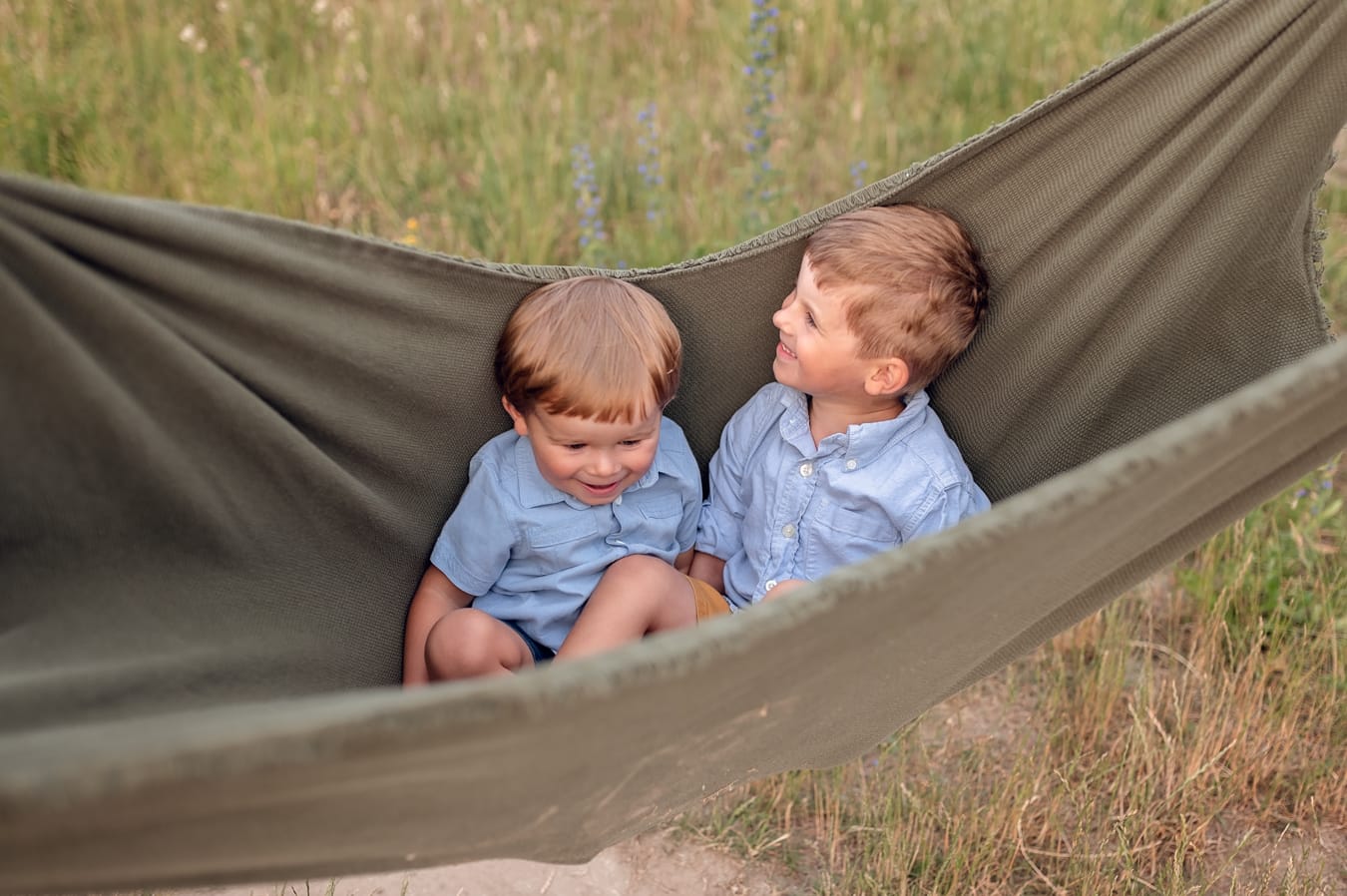 Chłopcy bujani w kocu na łące sesja rodzinna w plenerze Gdynia