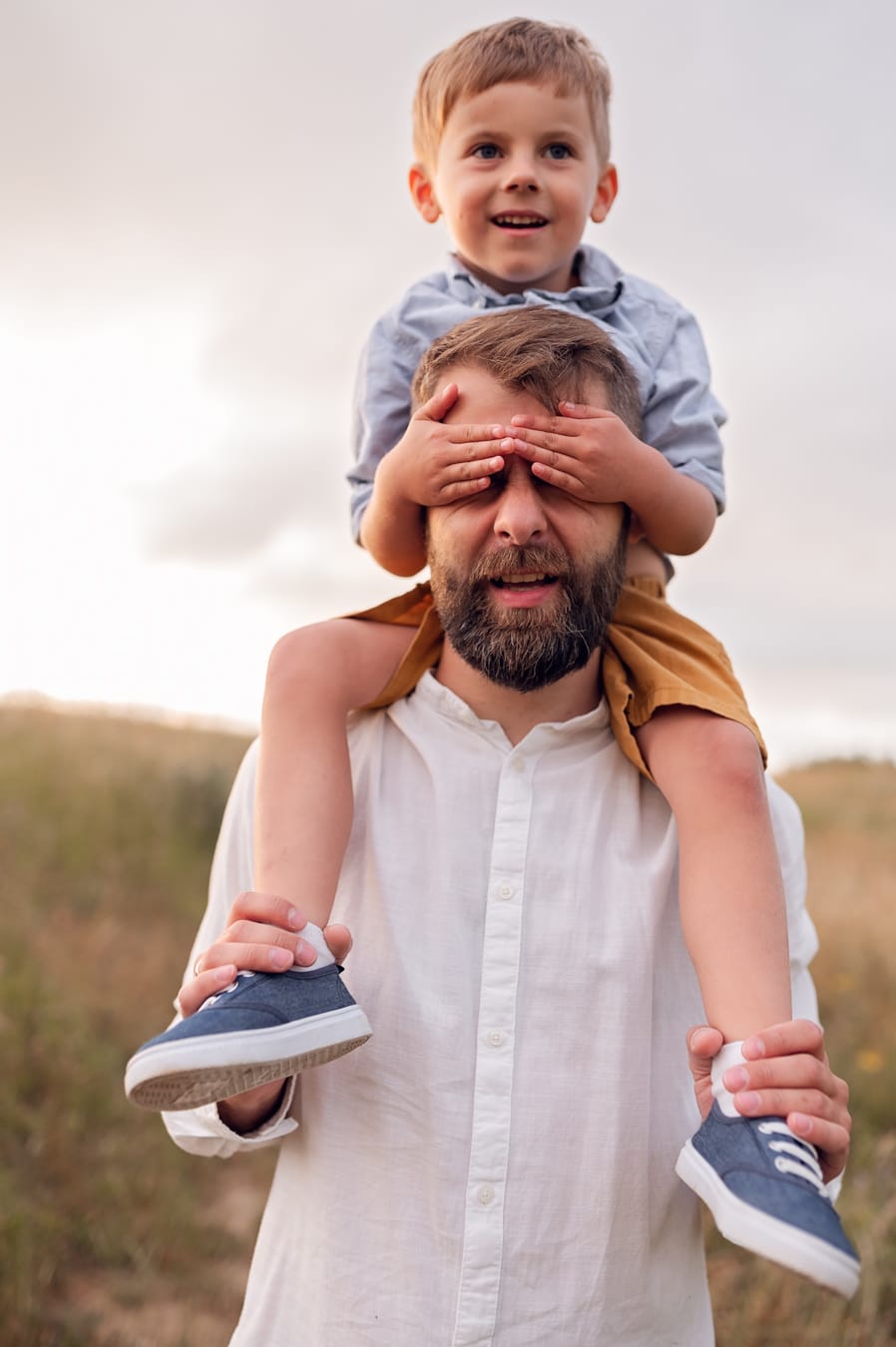 Syn na barana u taty zasłania mu oczy sesja na łące