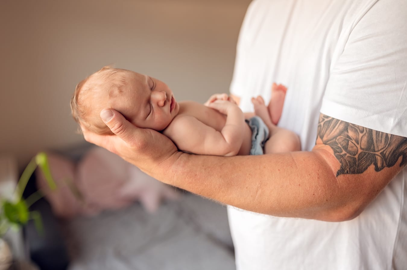 Noworodek na dłoni taty fotografia noworodkowa w domu