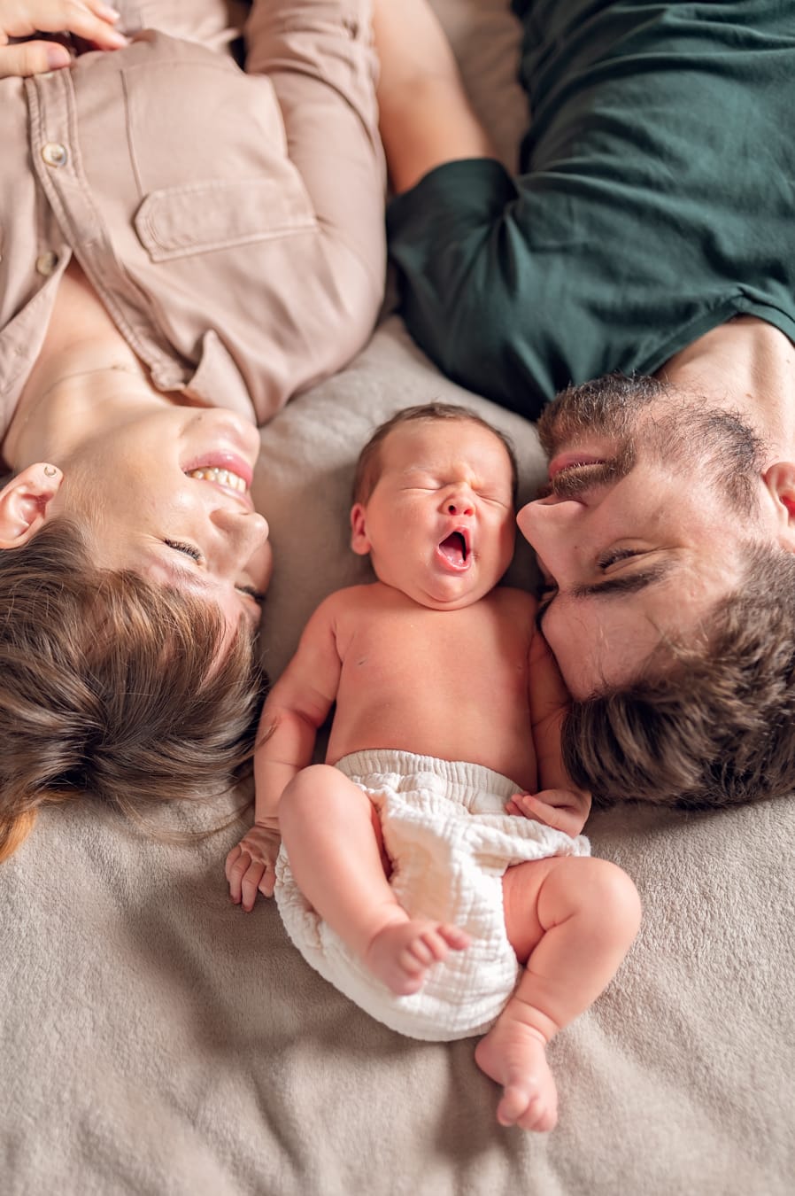 Ziewający noworodek między rodzicami sesja lifestyle Gdańsk