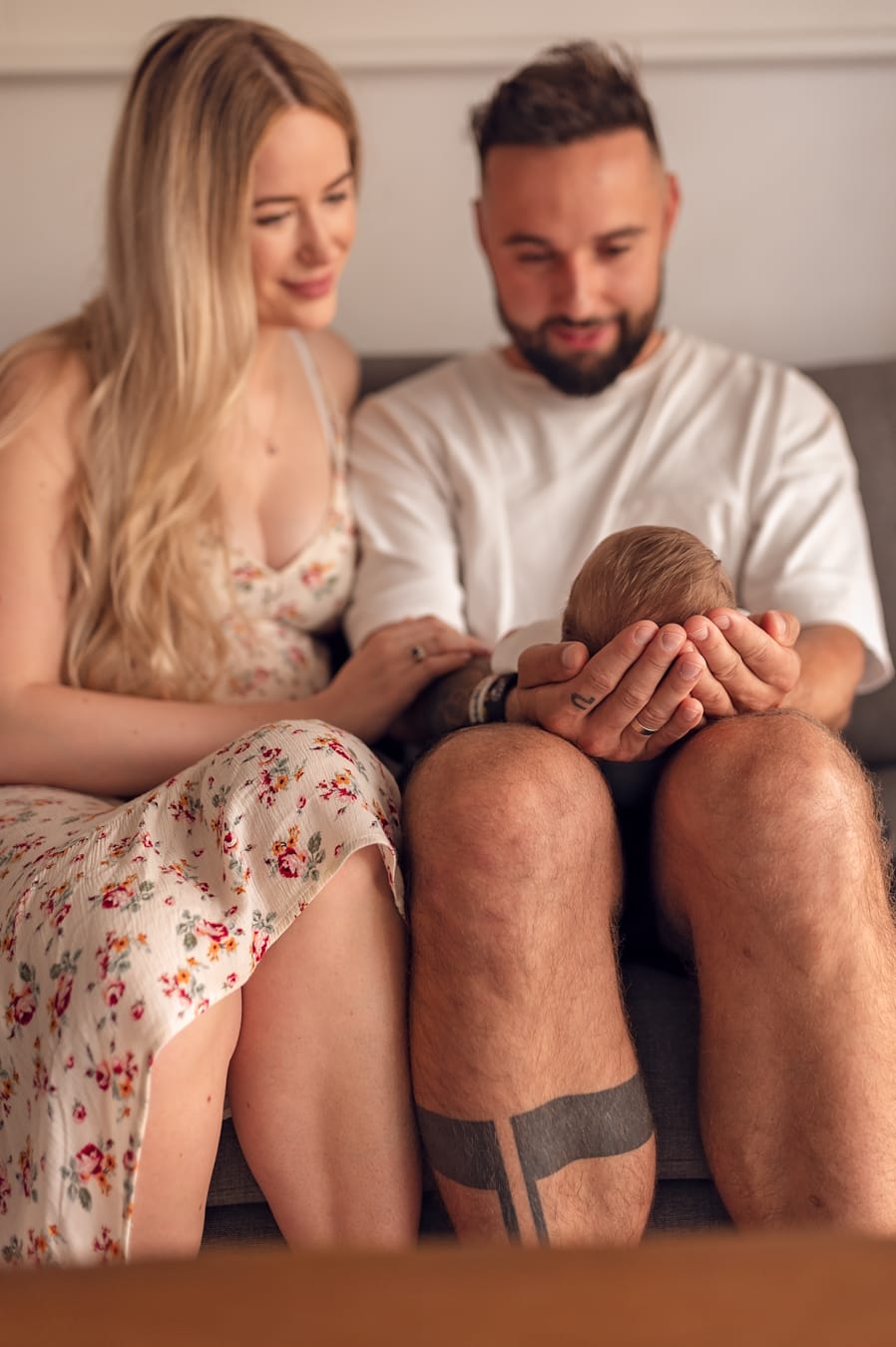 Rodzice patrzą na synka sesja niemowlęca w domu