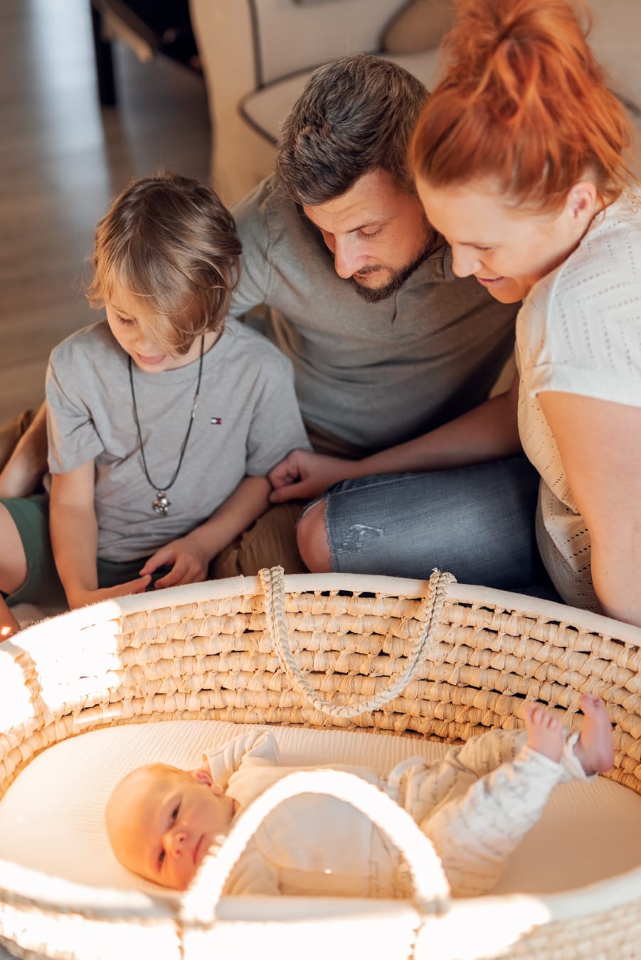 Rodzina patrzy na noworodka sesja w domu Gdańsk