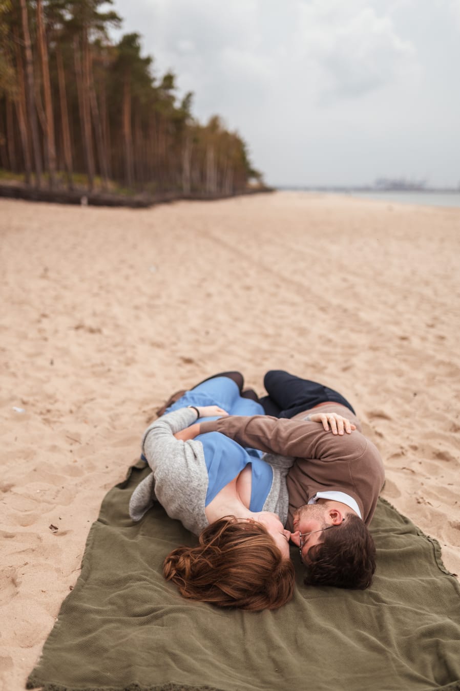 Para leży na plaży sesja ciążowa jesienią Gdańsk