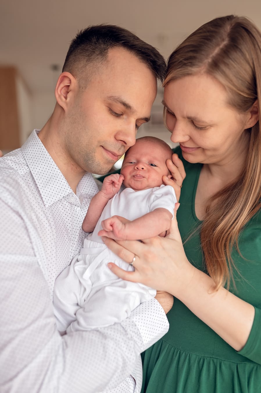 Rodzice przytulają noworodka rodzinna sesja w domu