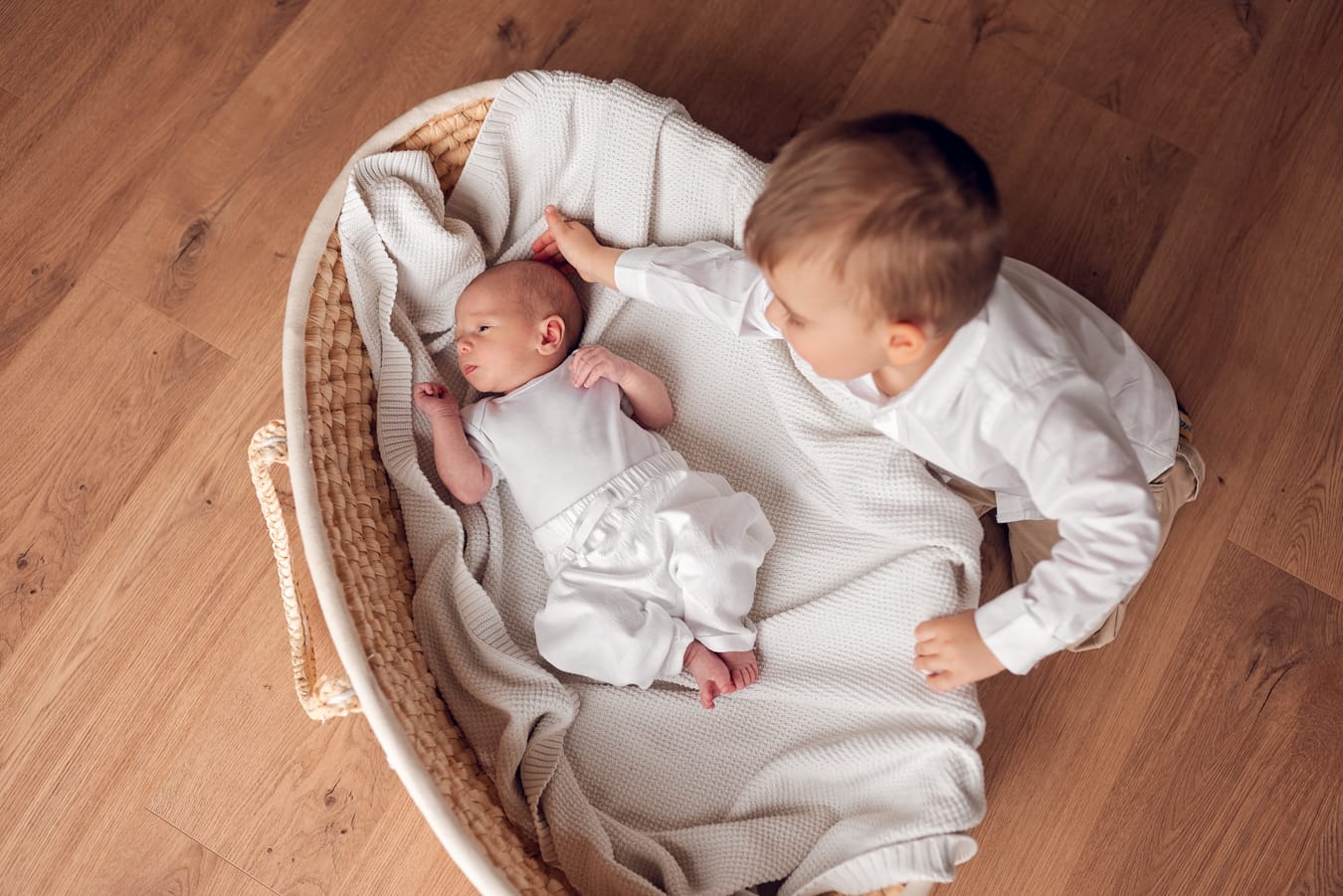 Rodzeństwo głaszcze noworodka rodzinna sesja w domu Trójmiasto
