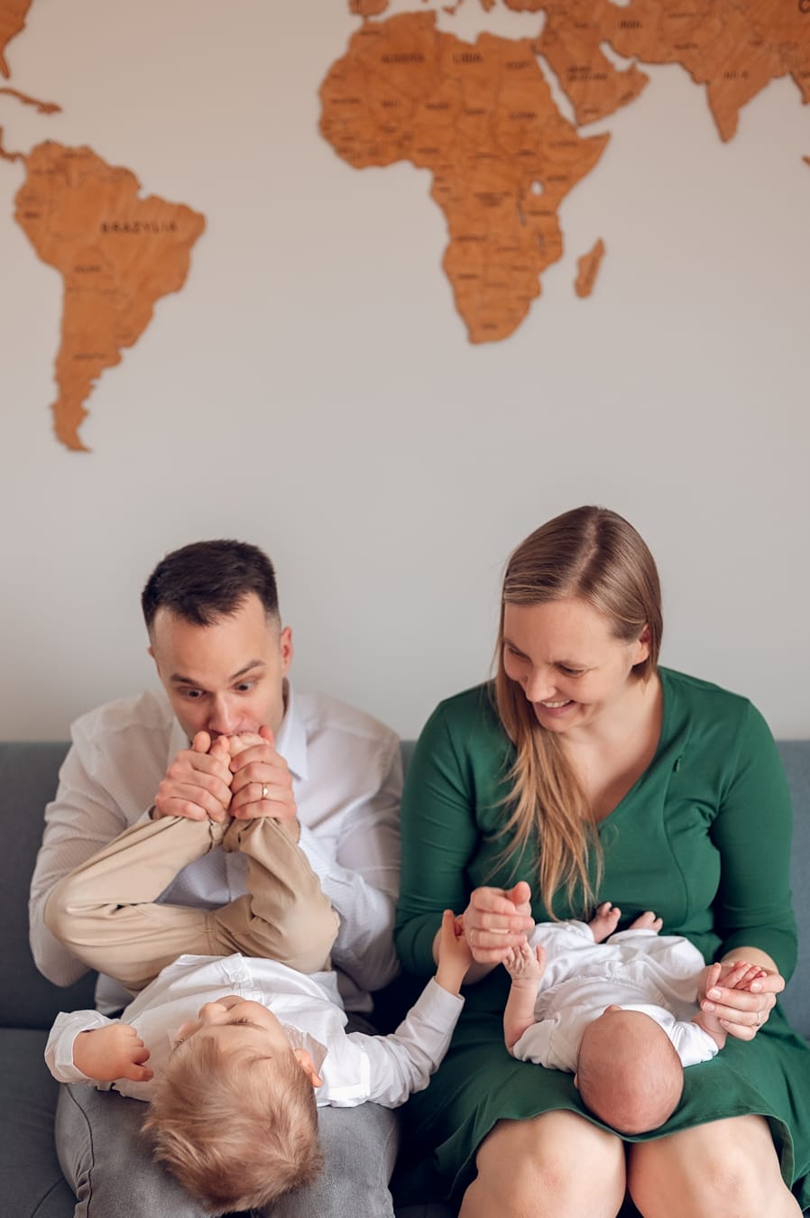 Tata całuje stópki starszego syna rodzinna sesja w domu