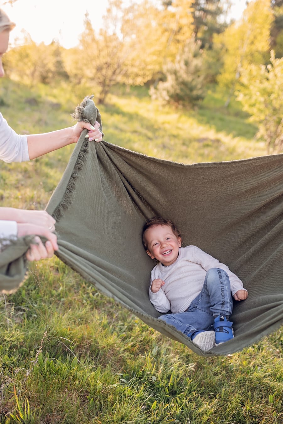 Chłopiec hustany w kocu na łące sesja rodzinna Gdynia

