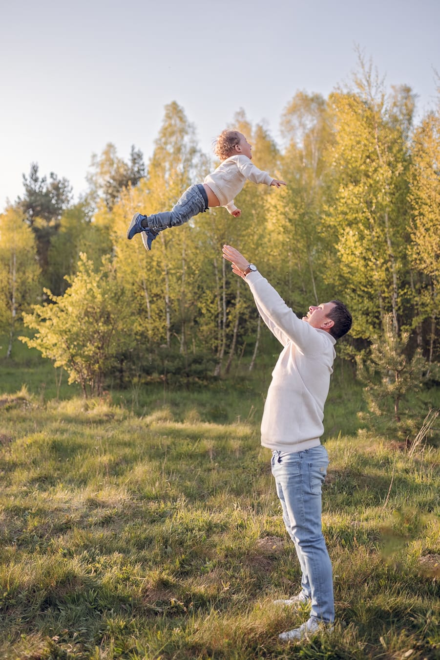 Tata wysoko podrzuca synka na łące sesja rodzinna Gdynia
