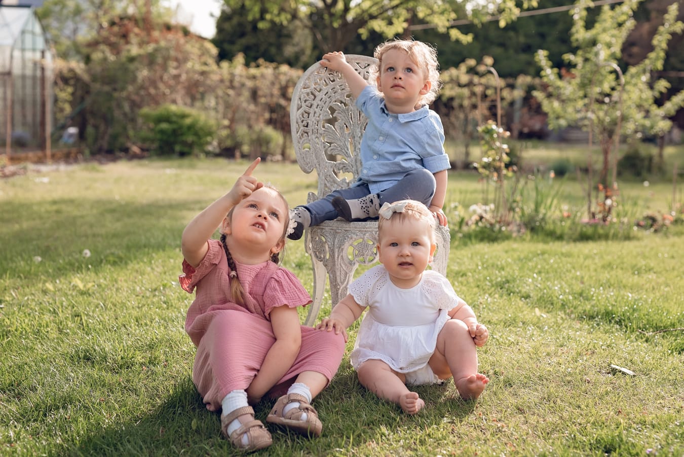 Kuzynostwo podczas wielopokoleniowej sesji rodzinnej w ogrodzie dziadków