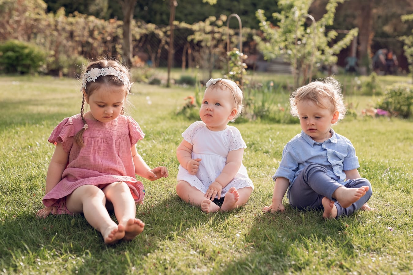 Kuzynostwo podczas wielopokoleniowej sesji rodzinnej w ogrodzie dziadków