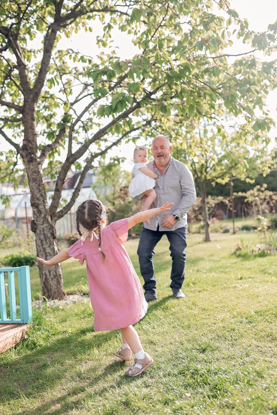 Dziadek z wnuczkami w ogrodzie, wielopokoleniowa sesja zdjęciowa