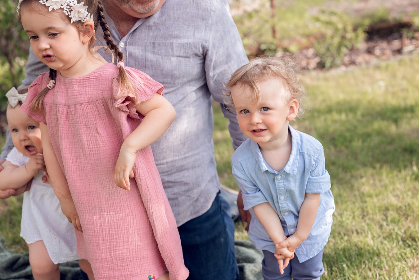 Ujęcie pełne uśmiechów i spontaniczności - wielopokoleniowa sesja rodzinna w ogrodzie dziadków