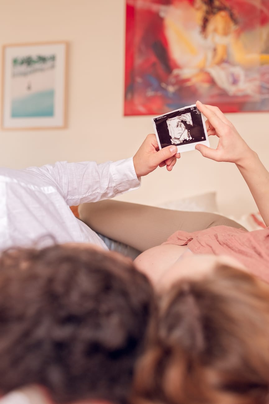 Para z USG na łóżku sesja ciążowa w domu
