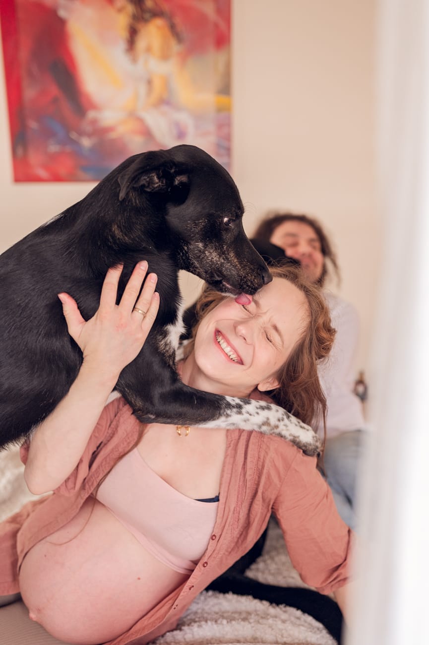 Pies przytula mamę w ciąży sesja ciążowa w domu