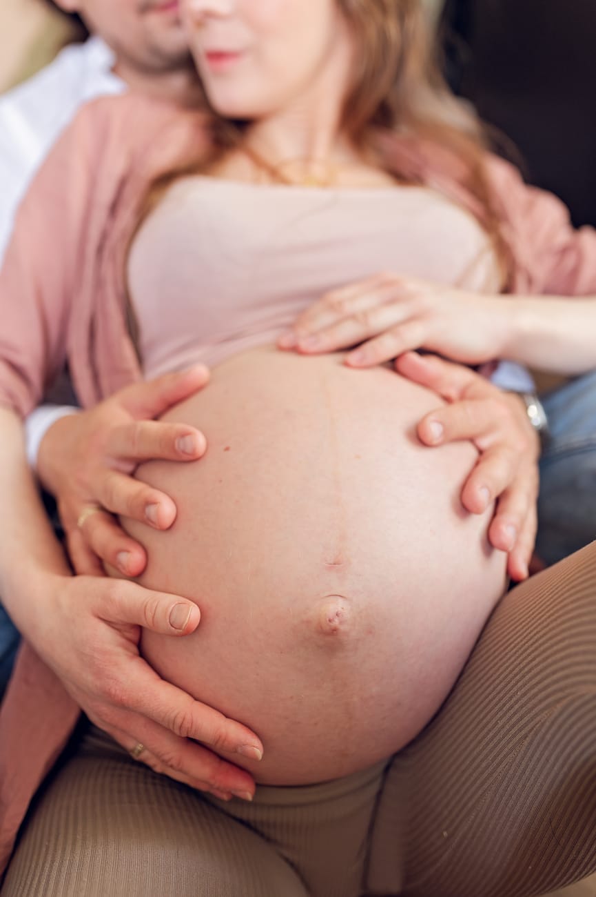 Dłonie na brzuszku ciążowym sesja w domu Gdańsk