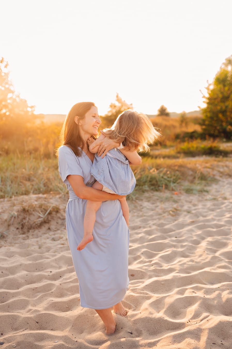 Mama i córka tańczą na plaży zachód słońca
