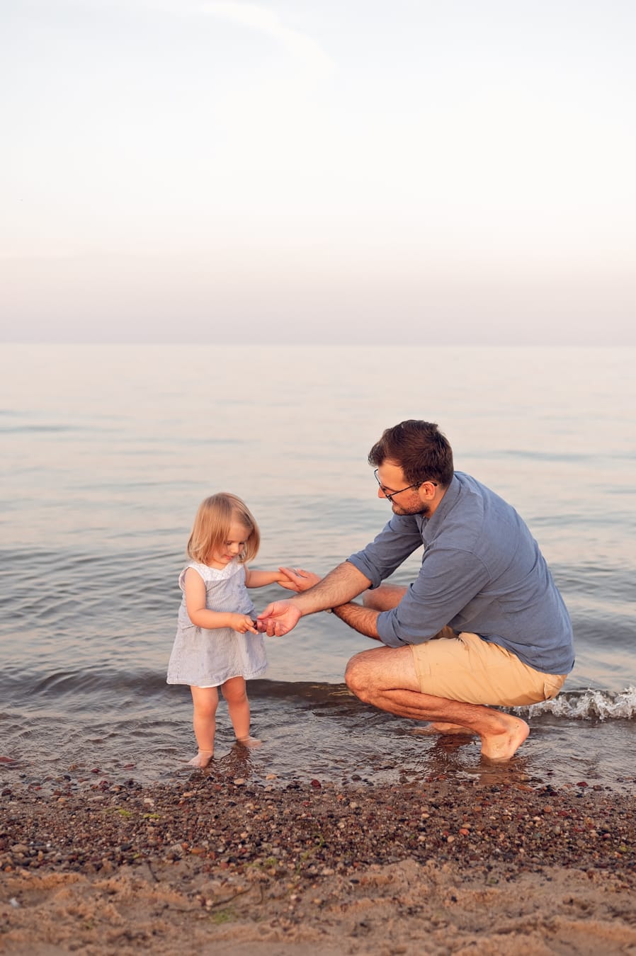 Córka z tatą zbierają kamienie rodzice w tle plaża
